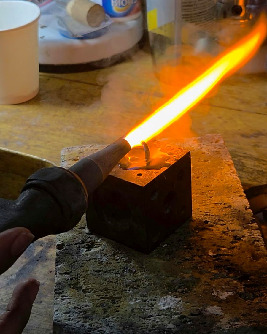 Goldsmith soldering a piece with a torch in the Kingdom Emeralds workshop in Cartagena